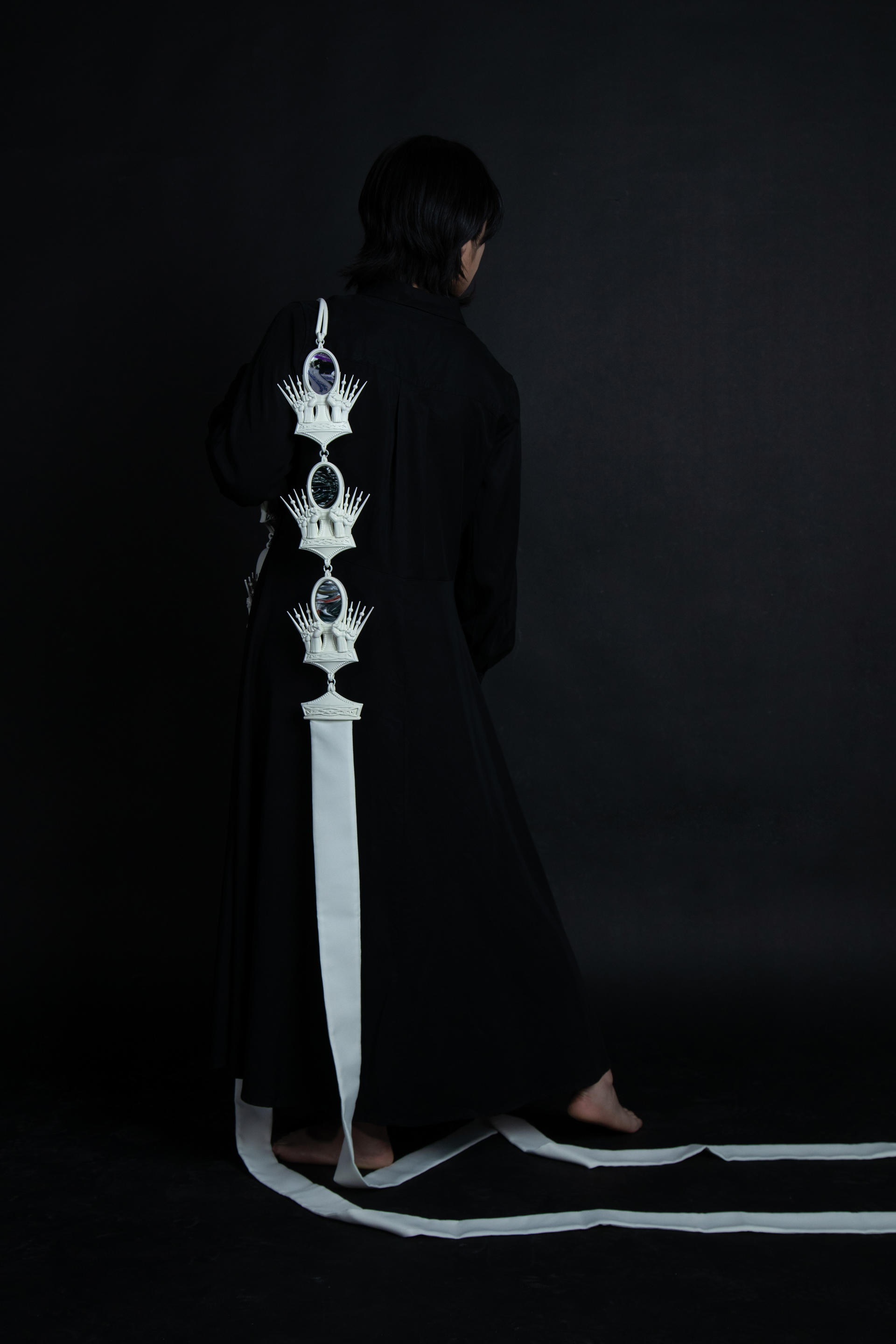 Model wearing a Uvoids jewelry piece in black background, Detailed view of a Unvoids jewelry piece on a black background, Rear view of a Unvoids jewelry piece in black background, Mid-view of a Unvoids jewelry piece, Showing intricate detailing