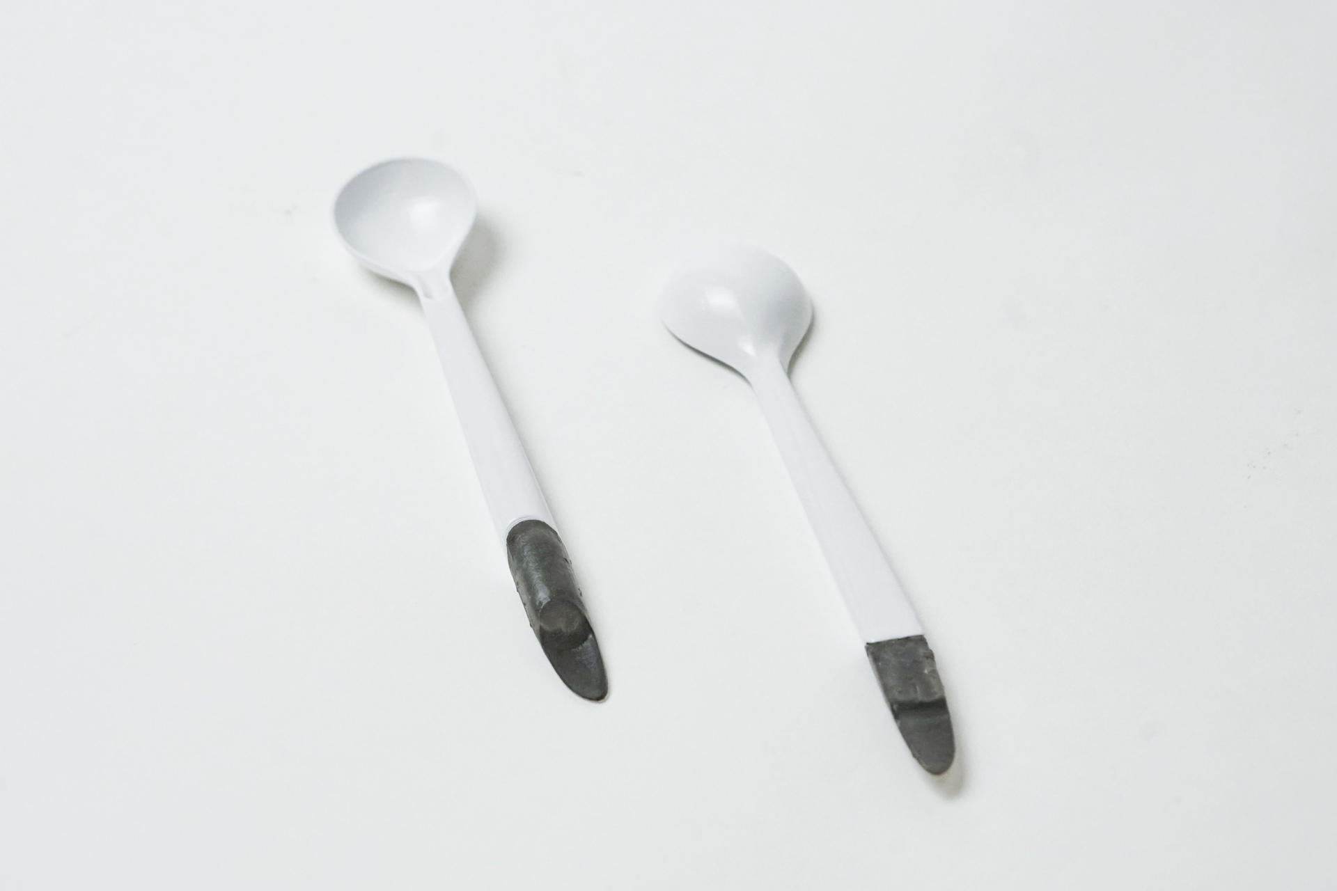 two white spoons with grey tails