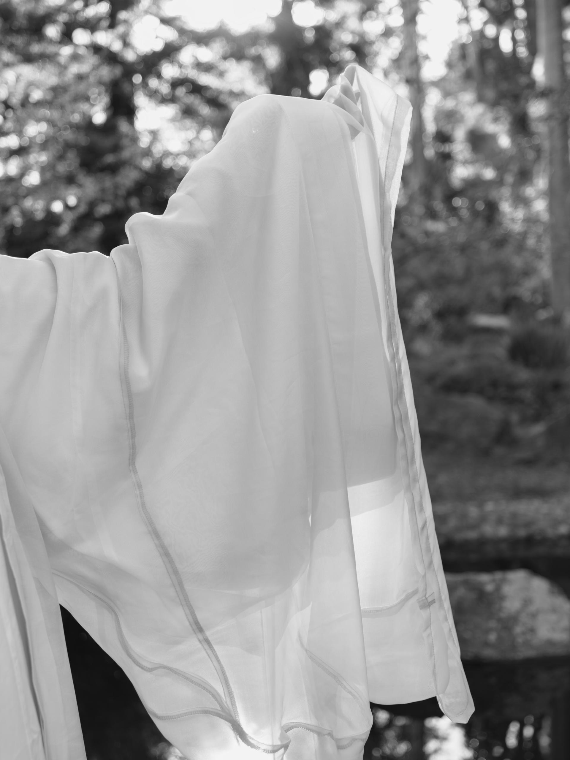 A partial of a figure wearing white silk