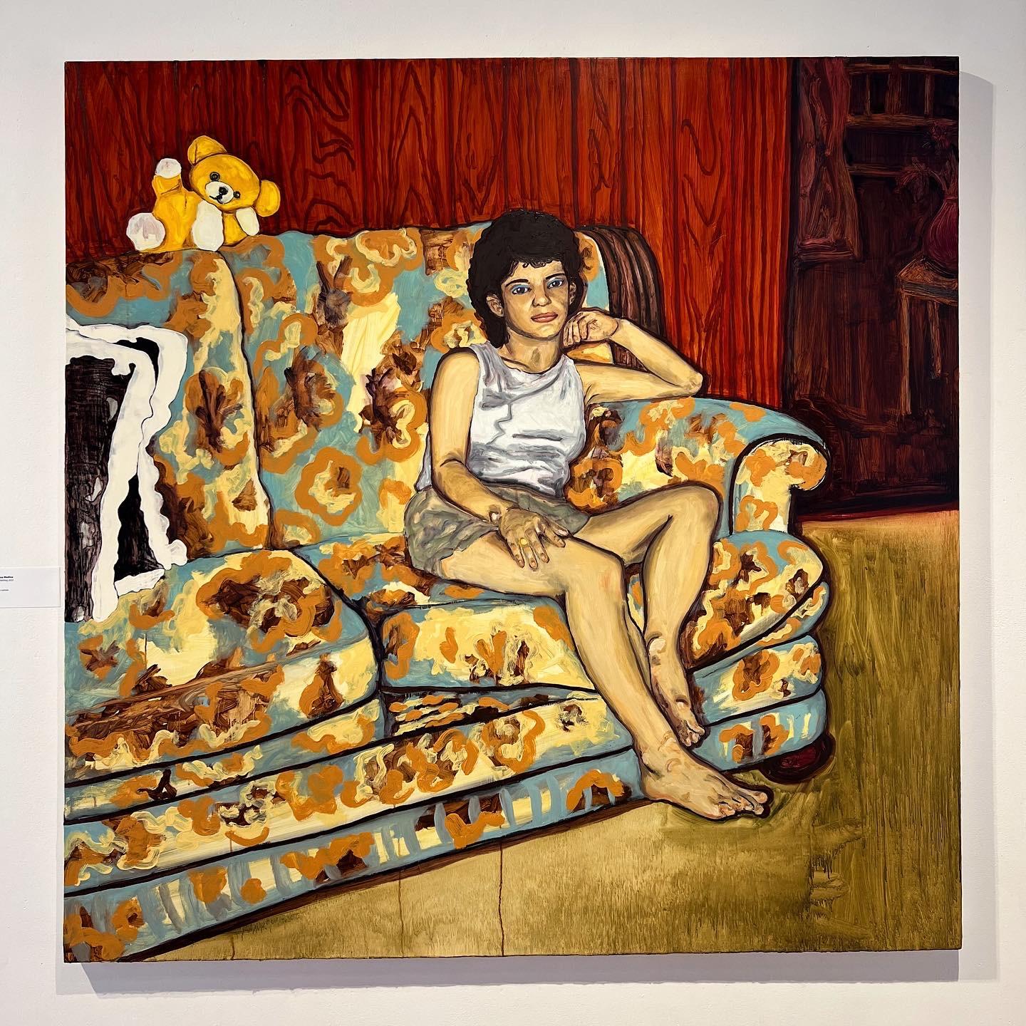 A female figure sitting on a floral couch