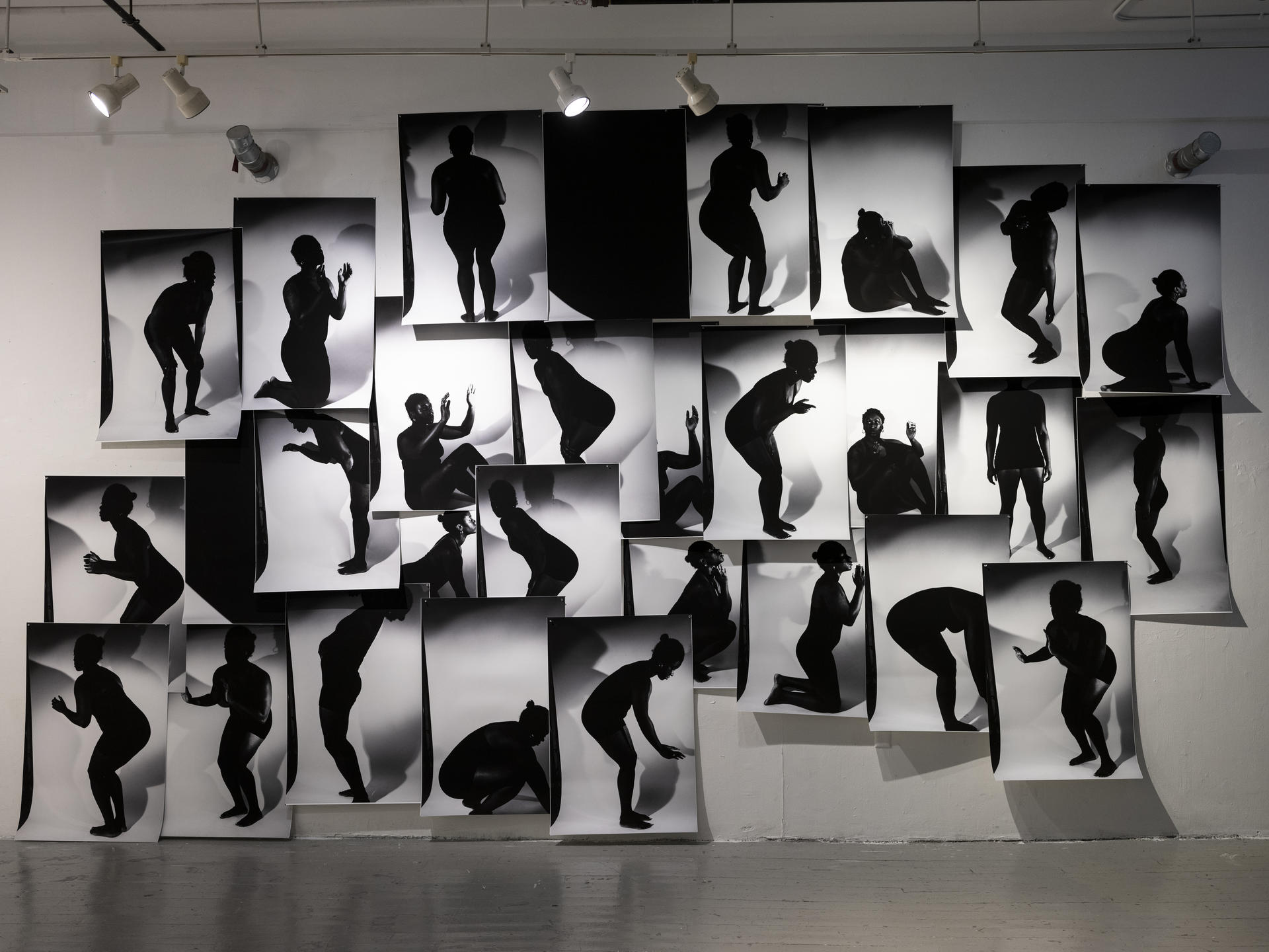 a massive collage on a wall with black and white silhouette images
