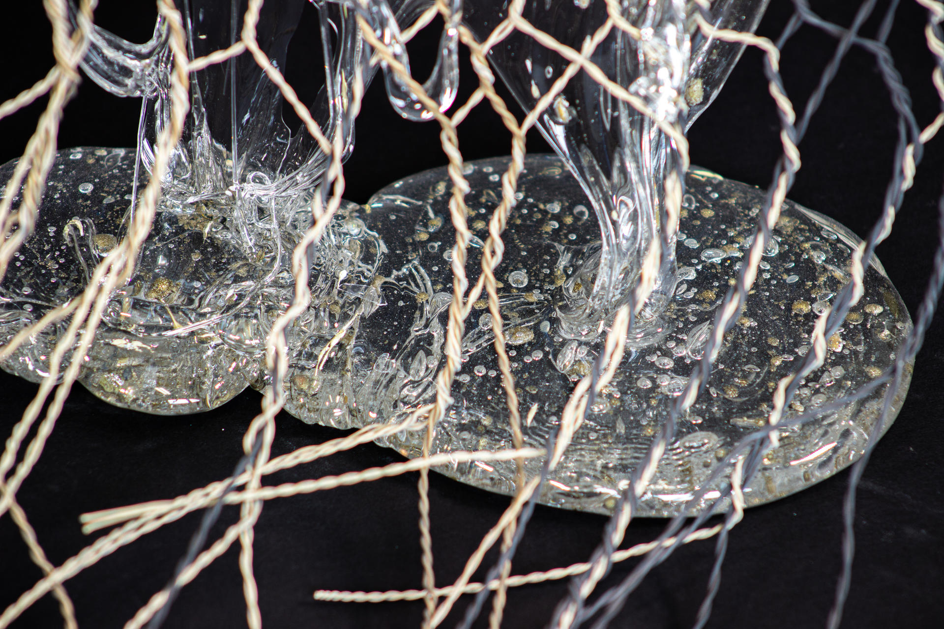 Piece of a hand-woven chicken-wire fence with molten glass encasing some 