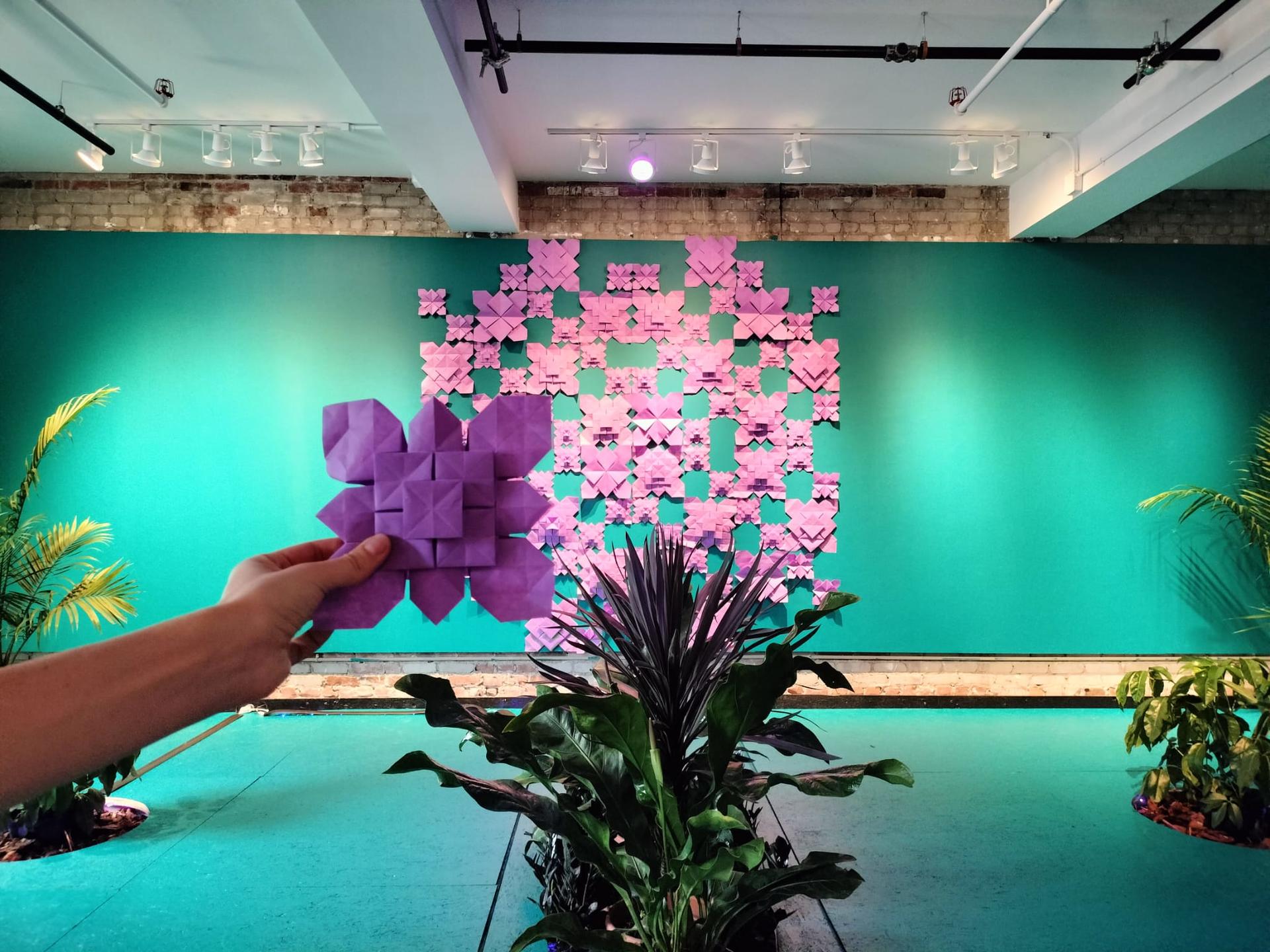 Purple fractals assembled on a teal wall. 