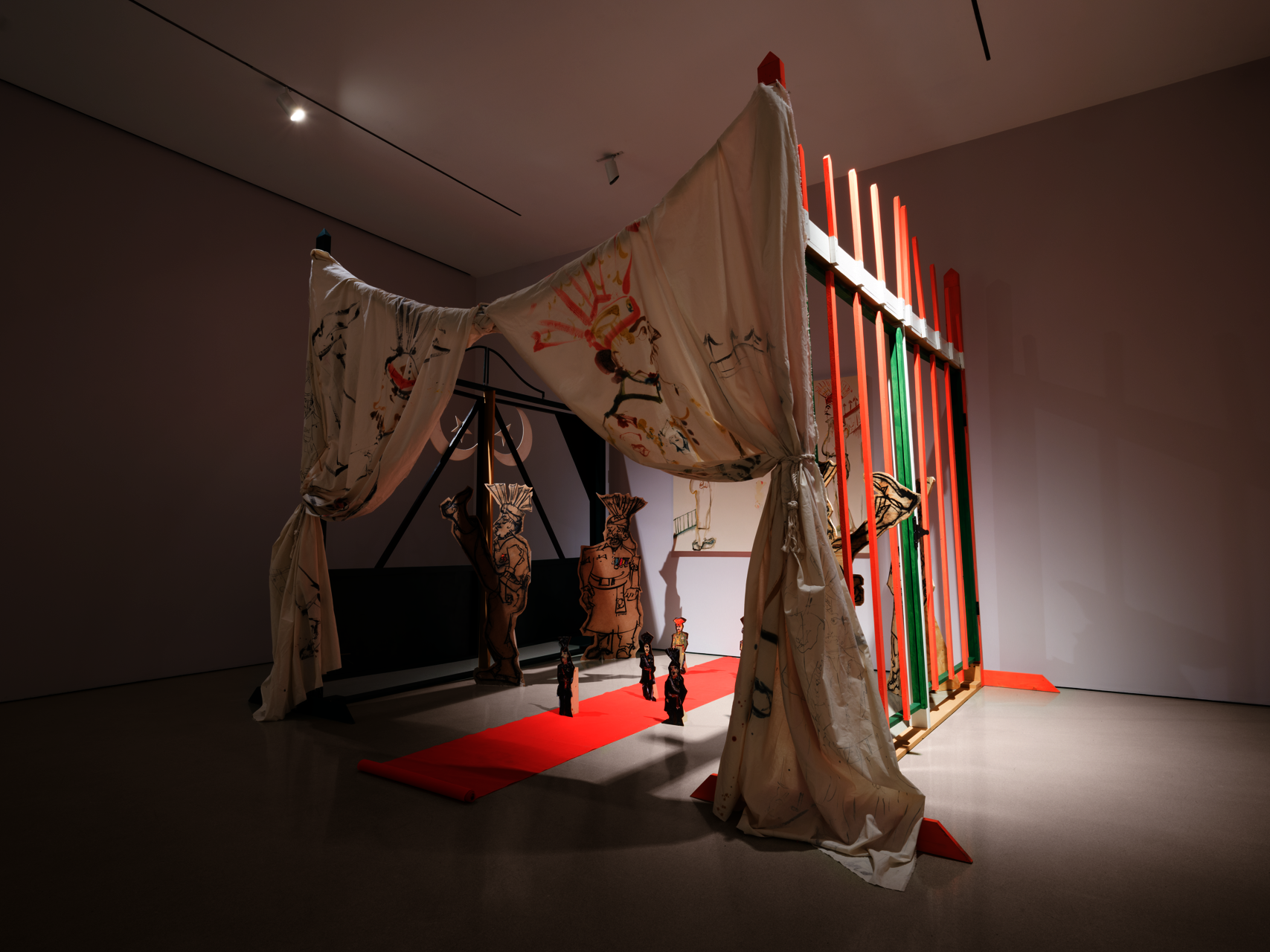 installation comprising oil painting on canvas, masonite, and muslin; charcoal and found fabric on wood cutouts, wooden handmade gates, sound, video performance (05:22), projection, carpet, and hardware
