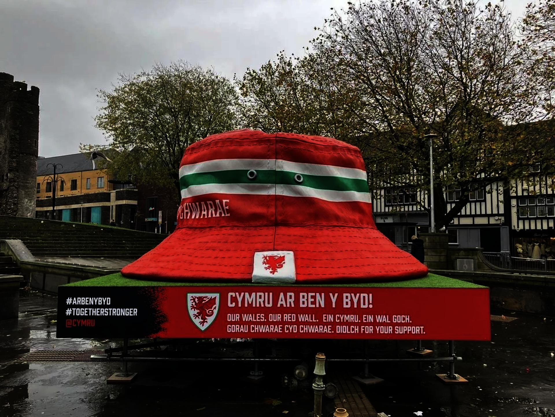 A giant red and green bucket hat sculpture in Swansea's city center.
