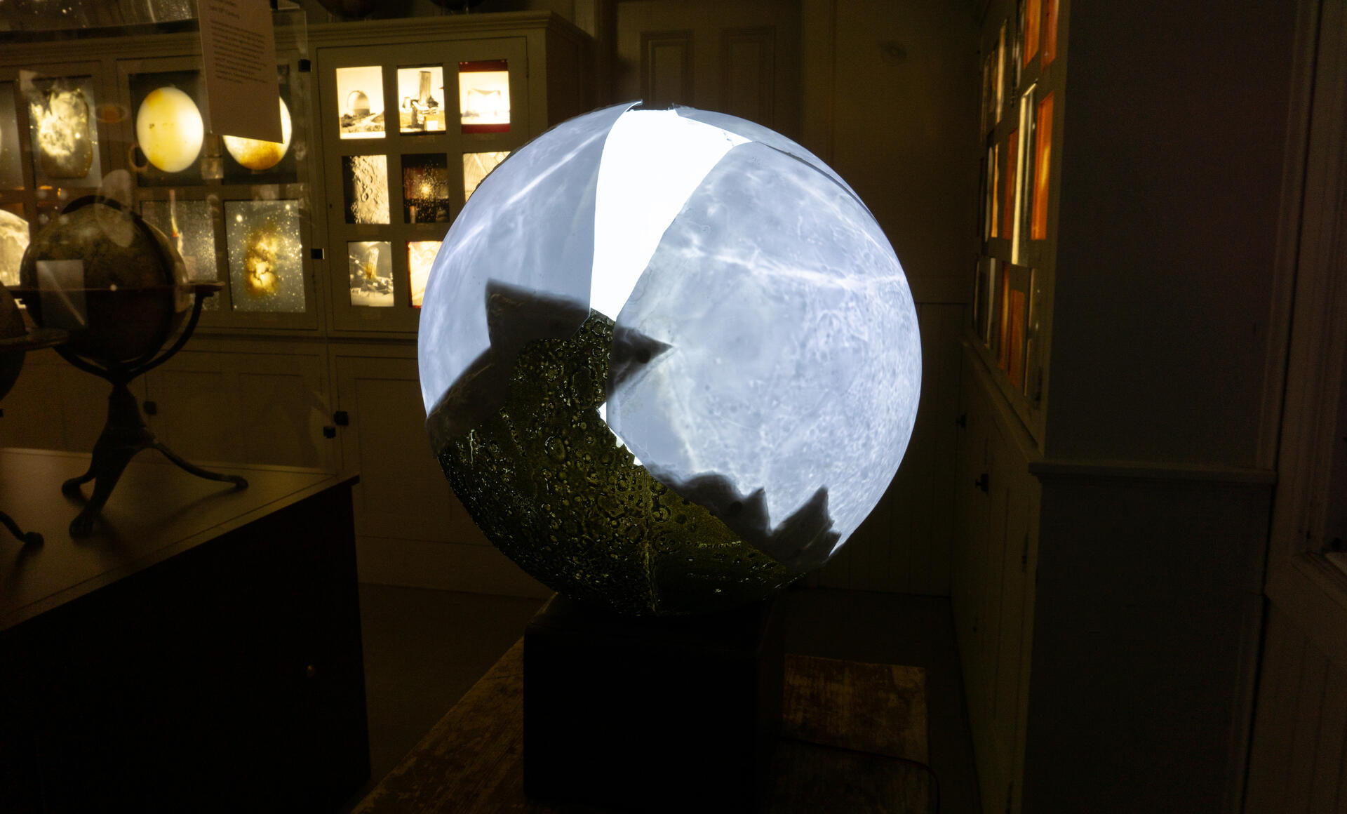 A broken moon model made by the Soviet Union is repaired by projecting from the glass ball inside onto the plastic shell.