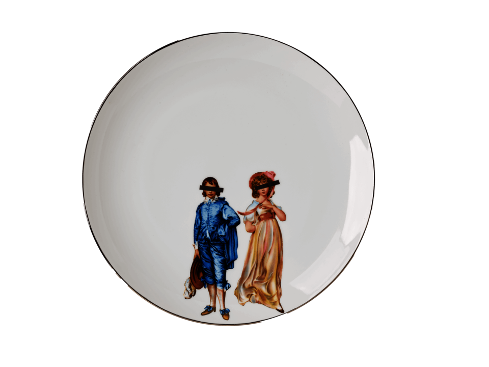 White circular plate with silver rim. Two figures at the lower center of the plate, one dressed in a blue outfit, the other in a pink dress, both with black, rectangular bars covering their eyes. 