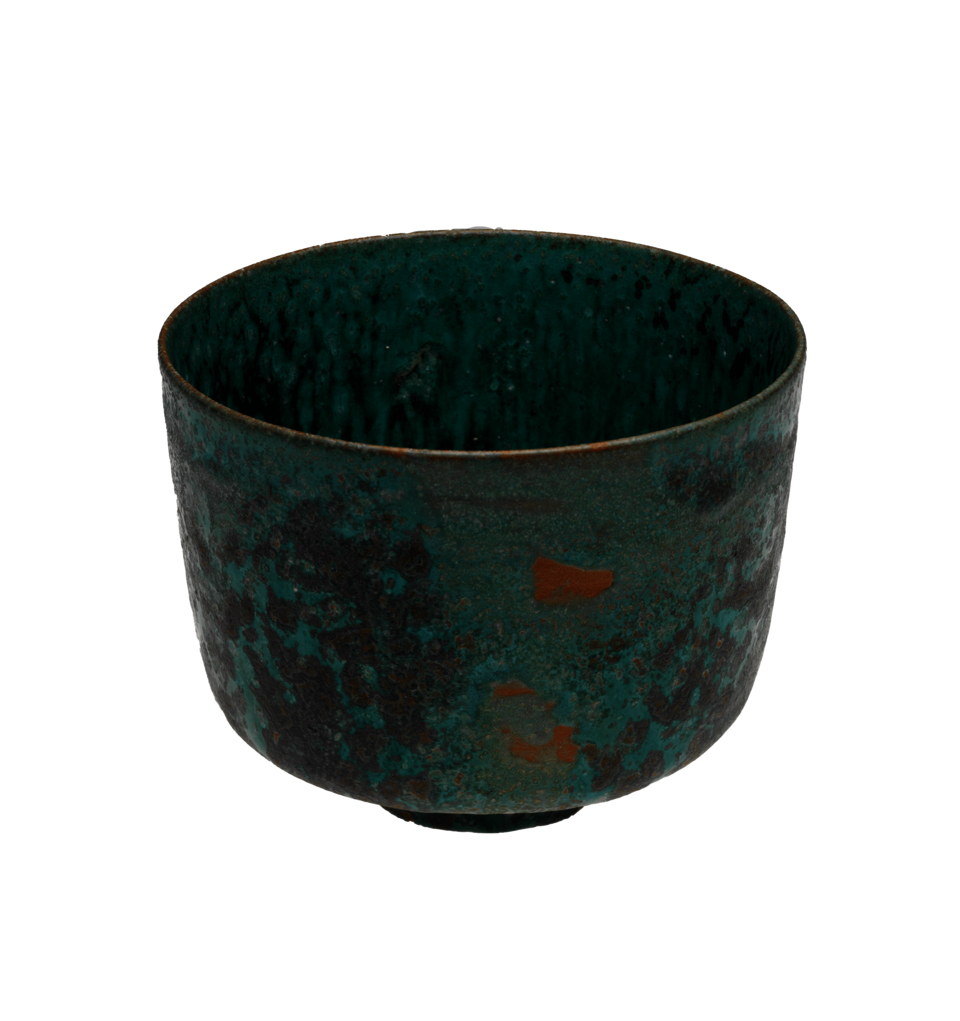 Thin-edged turquoise bowl, resting on a small round foot, with large splotches of dark blue on the sides. There are three small irregular orange marks in the center.