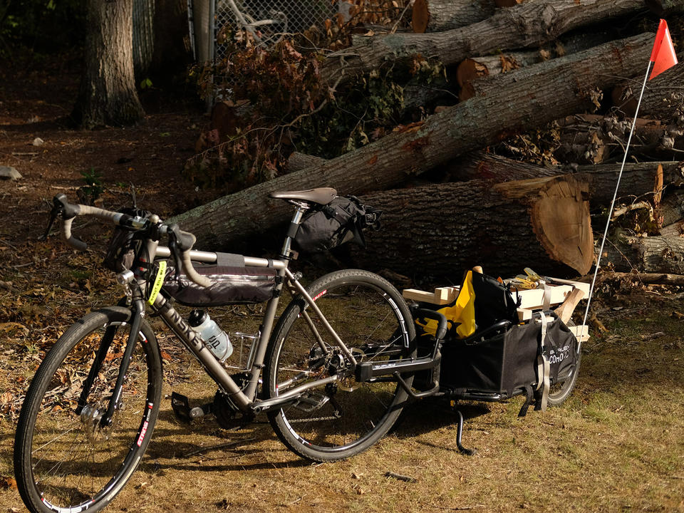 My bicycle and the trailer loaded up as my Manual Mobile Log Processing Unit in front of a pile of logs.
