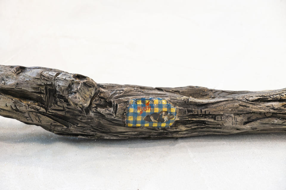 Detail of drift wood with patch of fabric depicting Saint Teresa in Ecstasy and the words "Rush". 