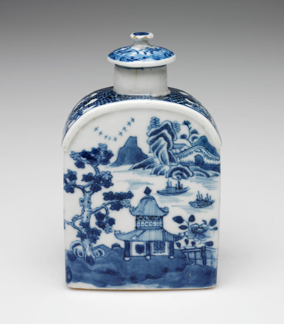 A rectangular vessel that curves at the top with blue and white decorations depicting architectural, floral, and landscape elements. The lid is circular and has a delicate finial.