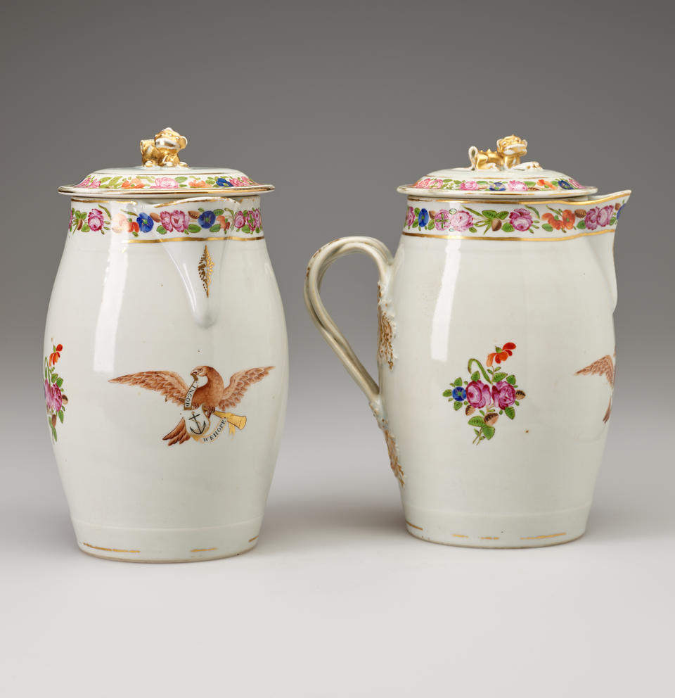 Two cream colored lidded vessels with decorations of flowers and eagles. 