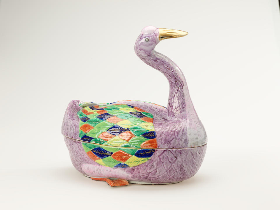 A sculptural vessel in the shape of a goose. The purple body is accented with diamond-shaped decorations in green, blue, yellow, and orange.