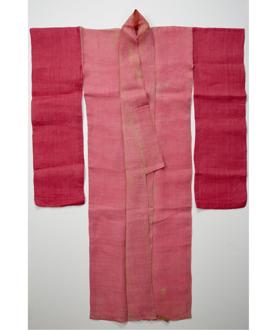 A pink kimono with an open orange collar. Laid flat, the shoulders of the kimono are squared off.