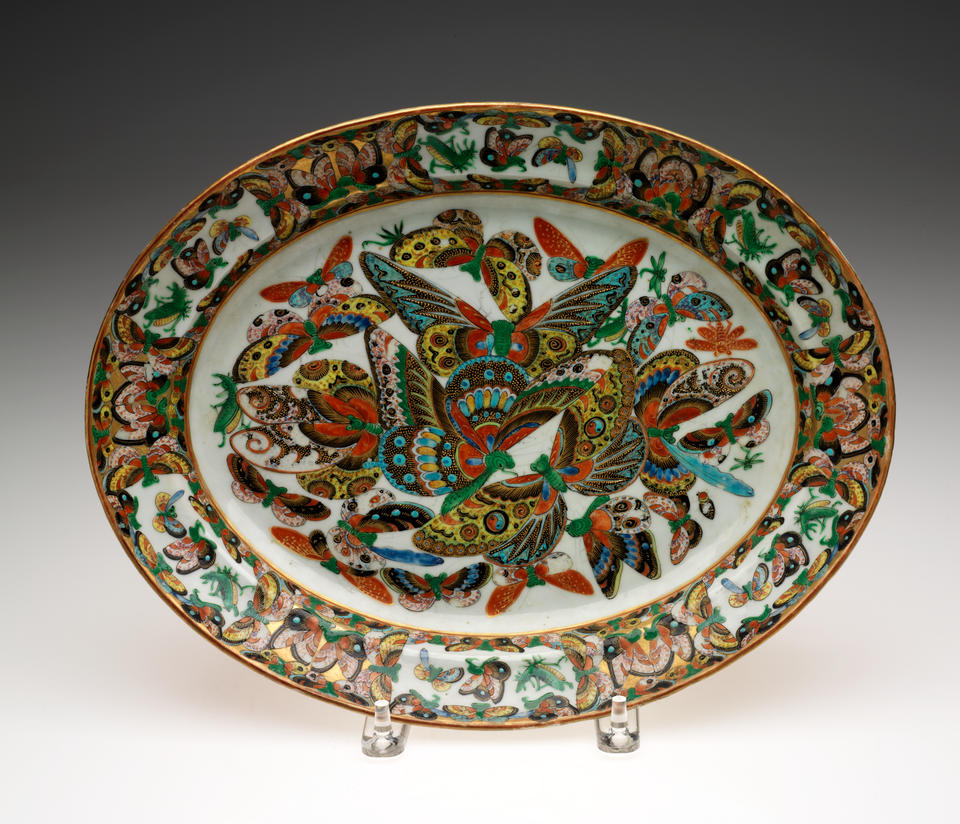  An oval serving dish. Decorated in the center with multicolored butterflies. 