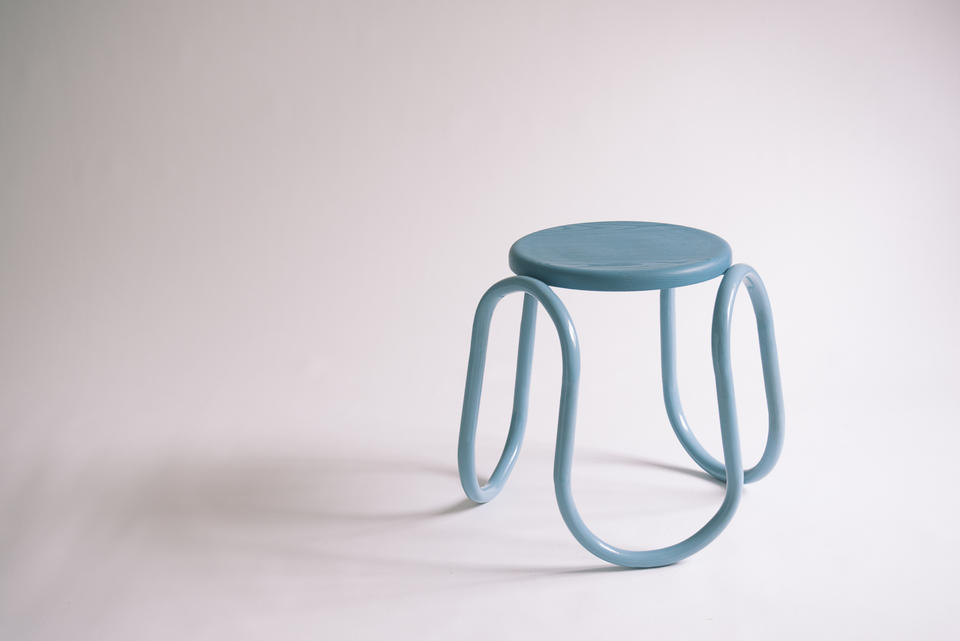 A blue wiggly steel tube frame with a circle ash seat. 