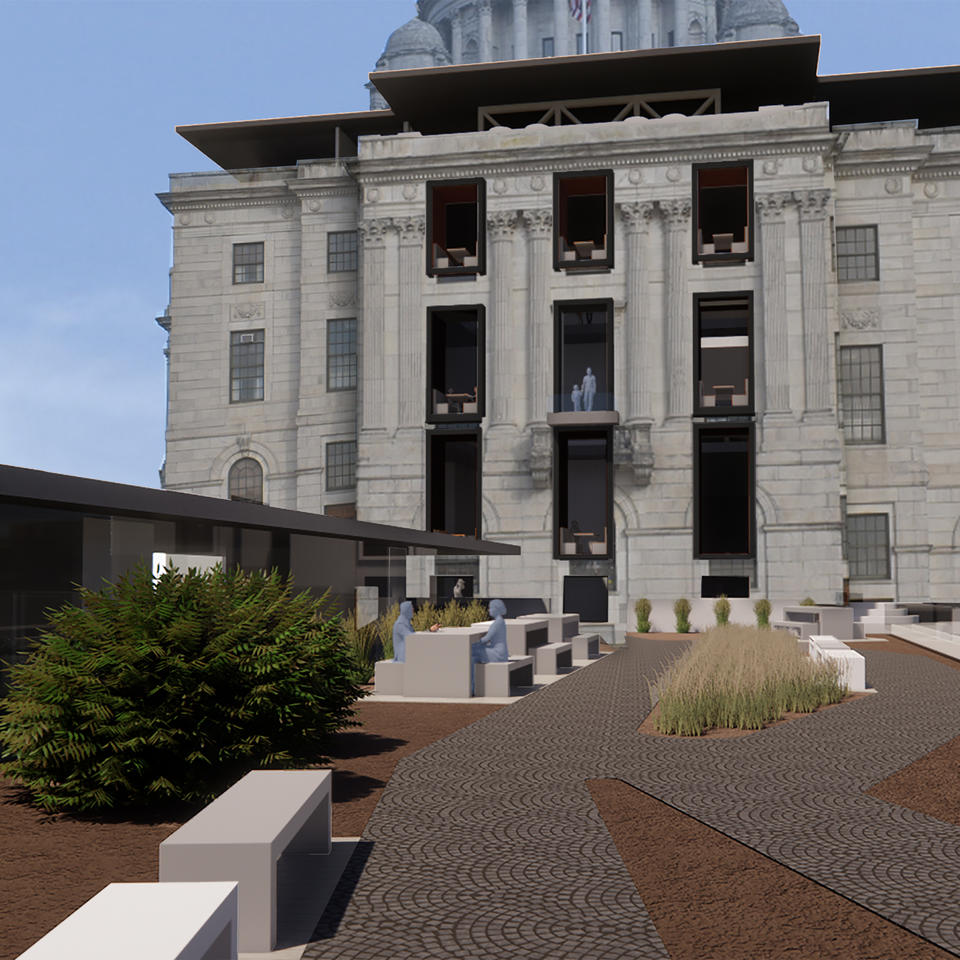 A bridge, hosting picnic tables and plantings, leads to the State House.