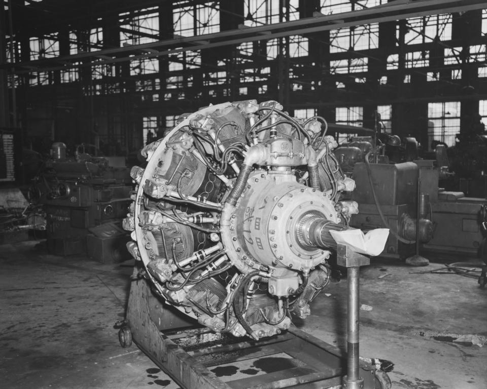 A black-and-white flash-lit photograph of the left-side posterior of a 1940's airplane engine.