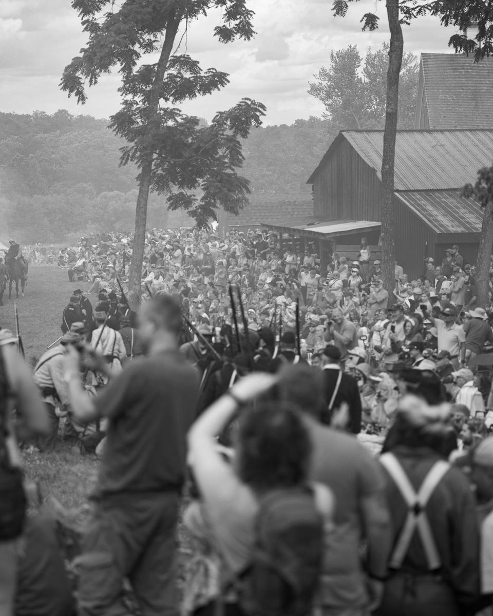 A smoky battle scene. It is hard to distinguish spectators from participants. 