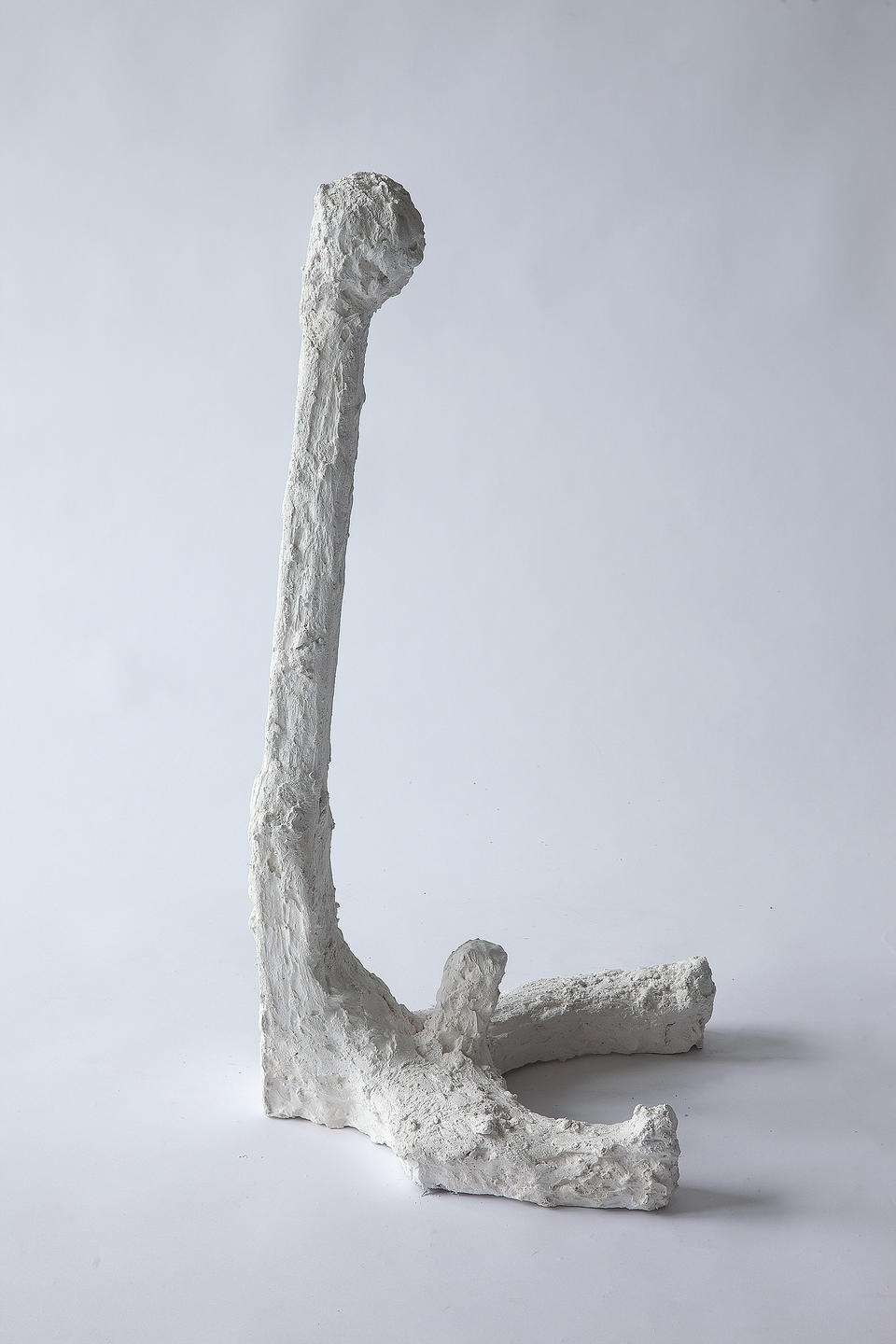 Plaster figure with a long neck and erect phallus