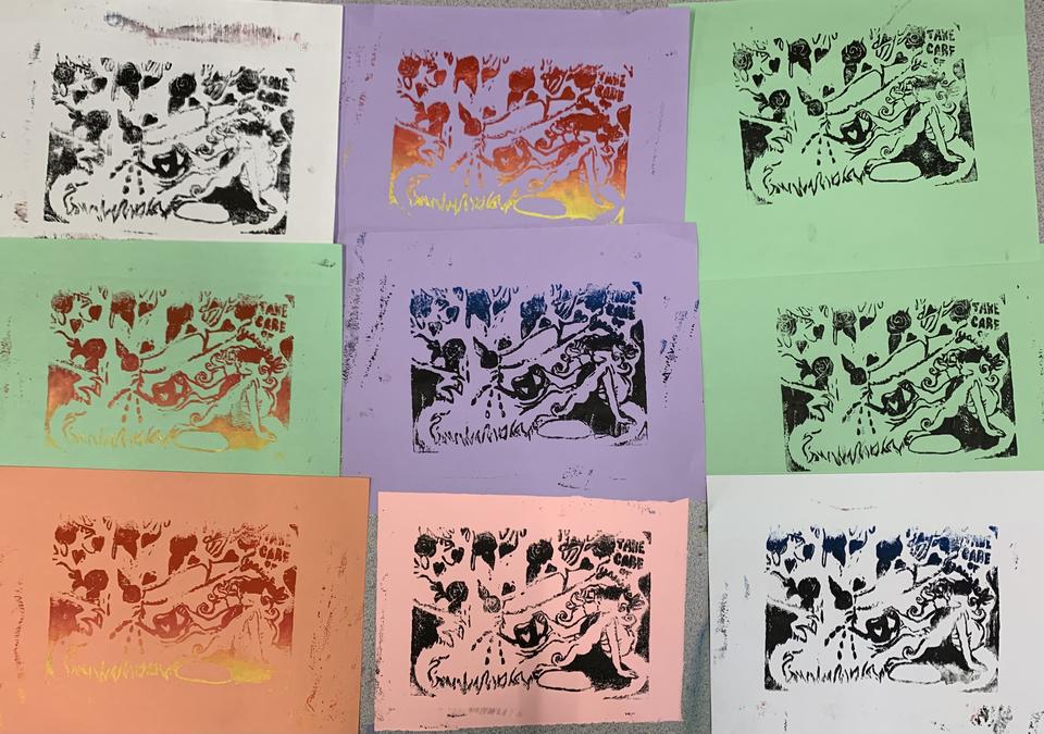 Various colored linocut blocks that have a girl watering a tree on them