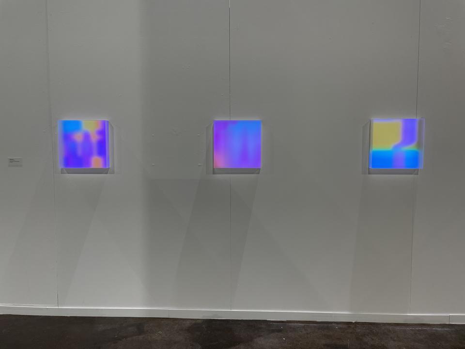 Photo documentation of installation featuring three light boxes.