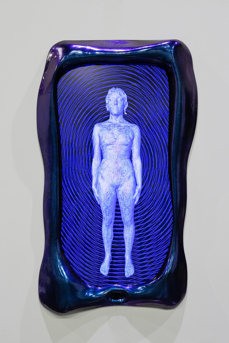 A blue and purple frame surrounds a screen showing a cyborg like figure