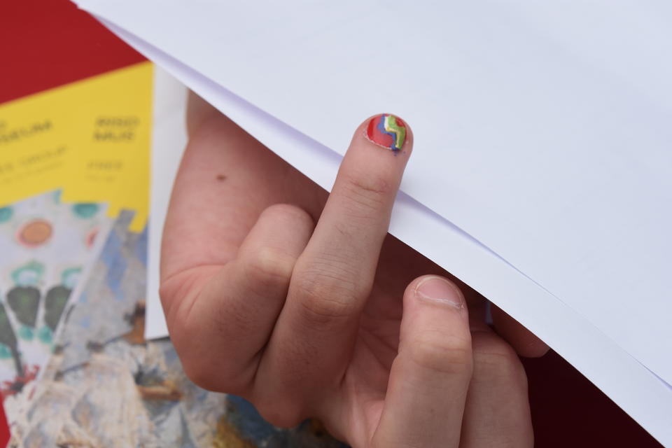 Someone holding out a finger out to display a single fingernail design from the makeover U-haul truck. 