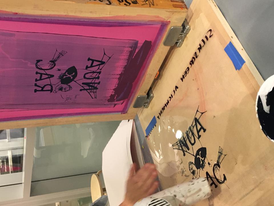 Screen printing screen with a design that featured NUA (New Urban Arts) and RAC (RISD Art Circle) with a small spider