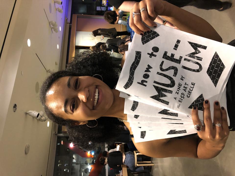 Teenager holding zines about the museum design by RAC