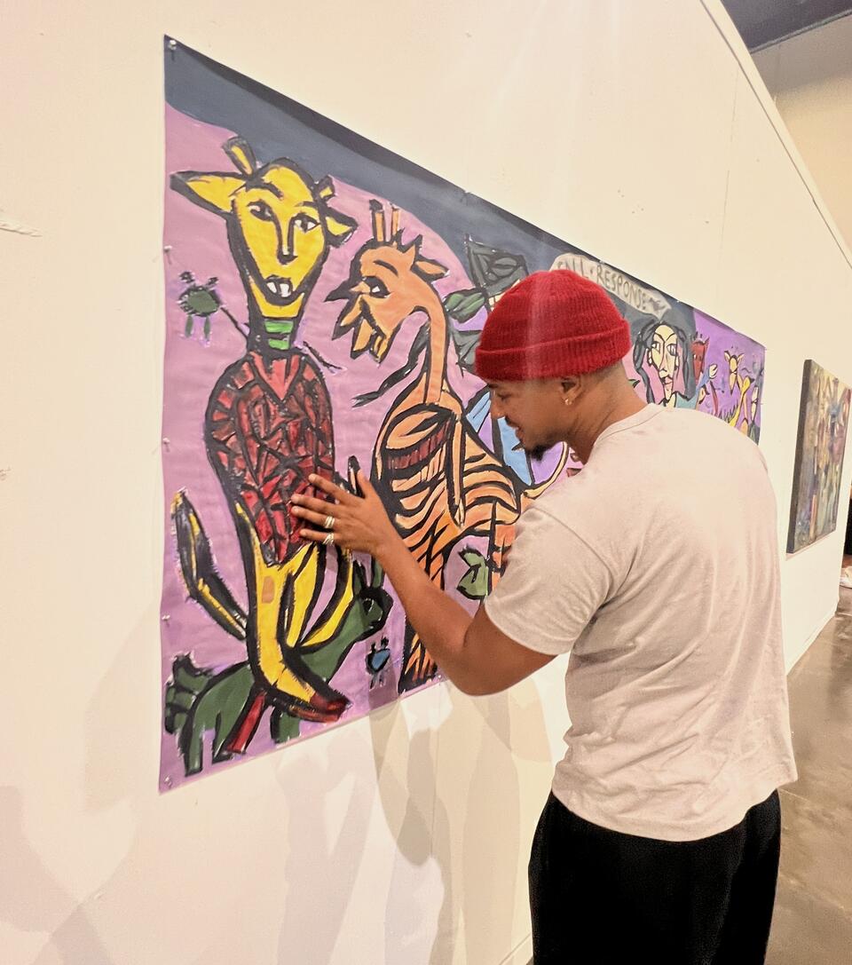 a person with a red hat touching the painting