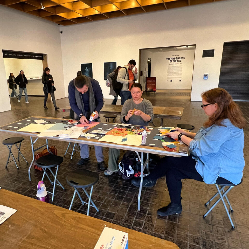 Participants of the workshop work around a table on a collaborative Illustration