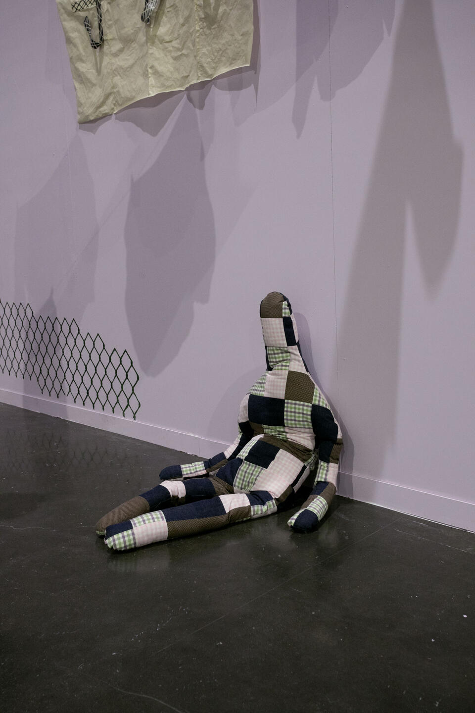 image of quilted stuffed human-like doll, sitting on the floor hunched over