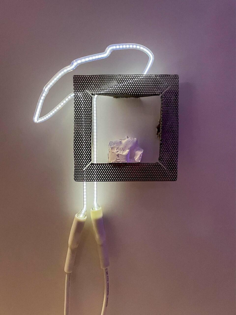 white silouette with a slight purple hue, facing upward within the frame of perferated steel, a squiggle of neon light in a white color with dotted pattern and wiring is to the left 