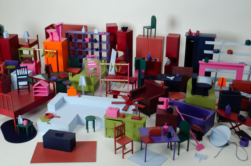 zoomed in, cropped, group photograph of all the everyday objects made at 1:12 scale. They are painted in a color palette of hot pink, deep red, orange, purple, navy, pale blue, dark green, and a deep chartreuse. 