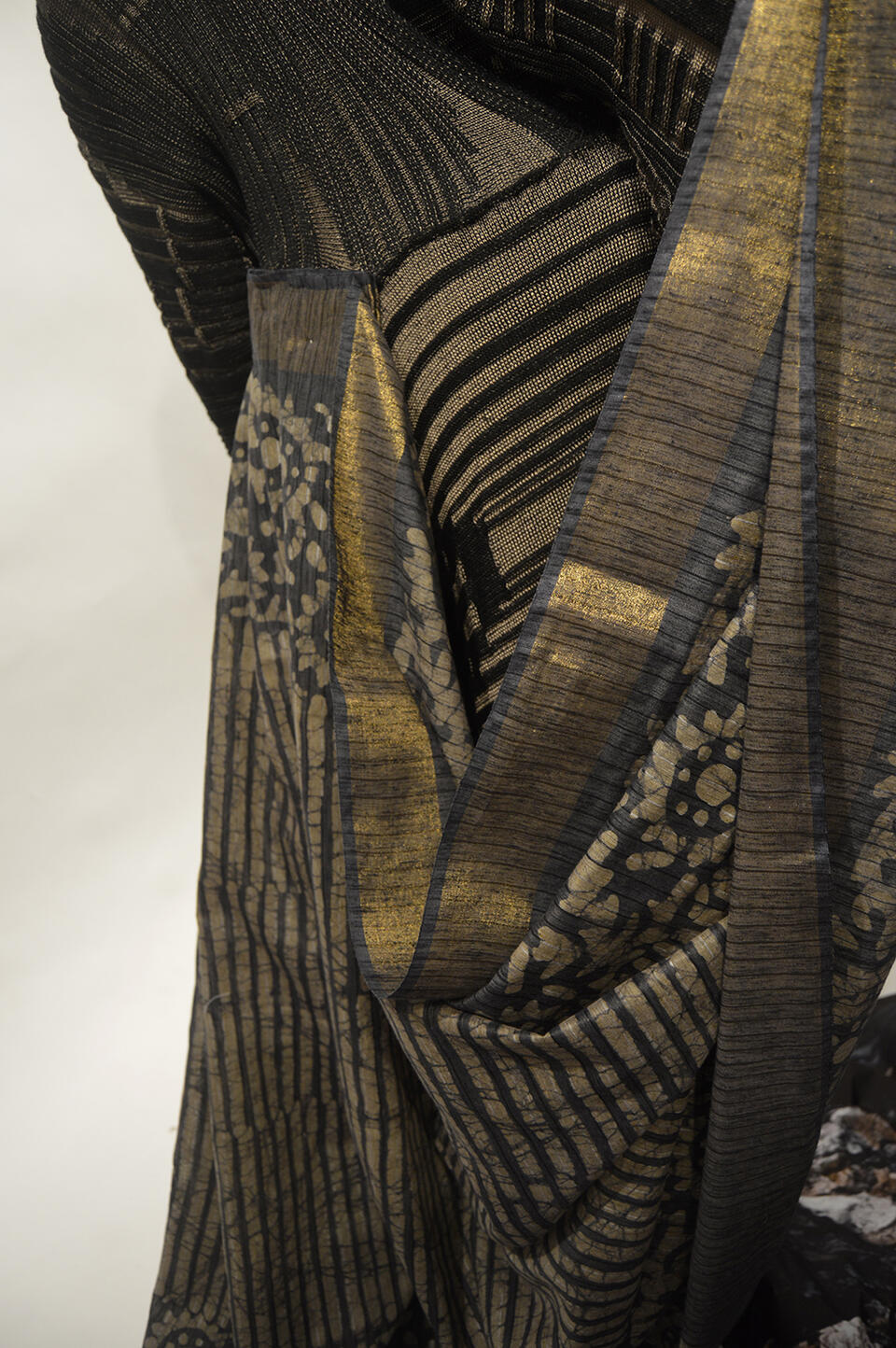 The details of the pleated sari communicate with the rib structure of the knit fabric.