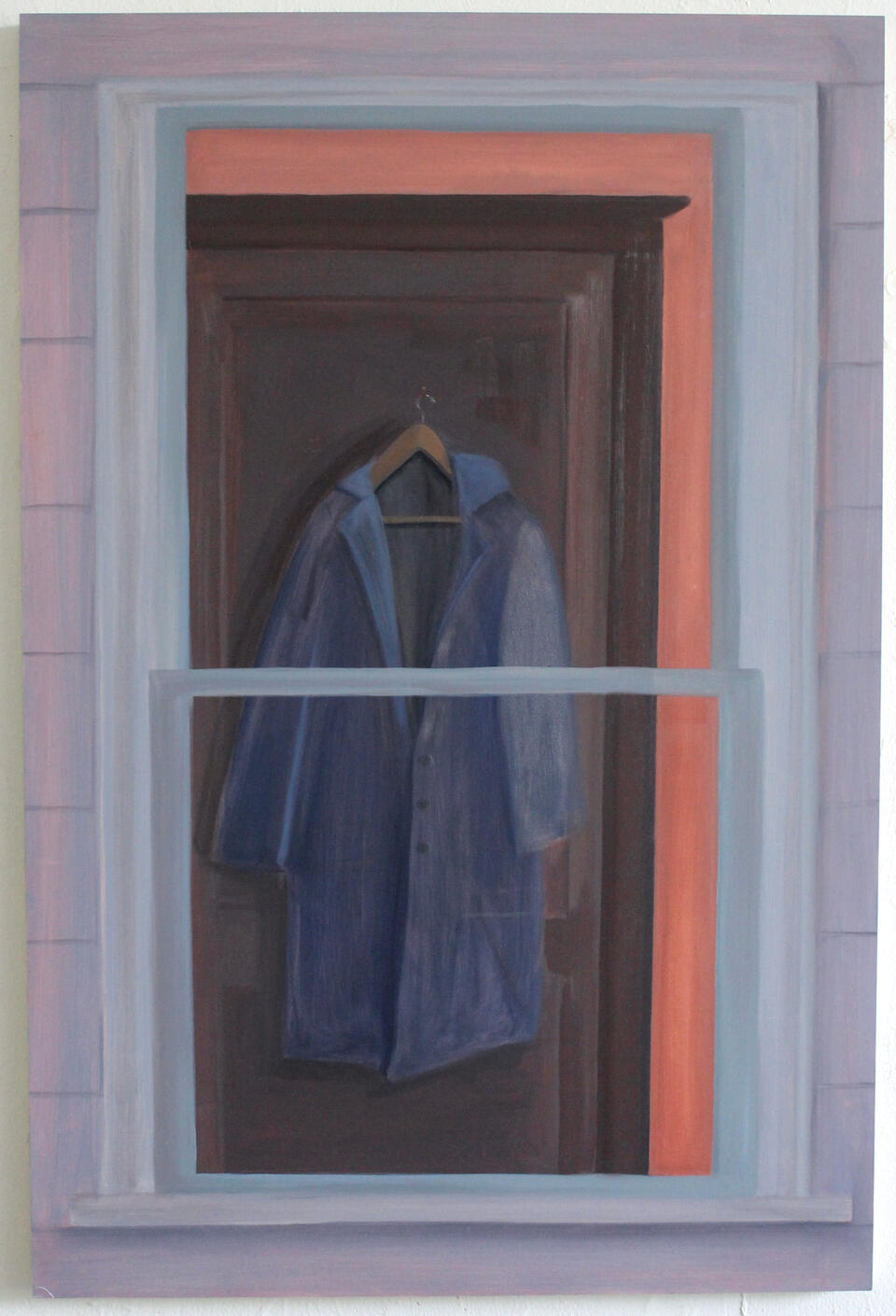 A coat hangs on a door, seen through a window.