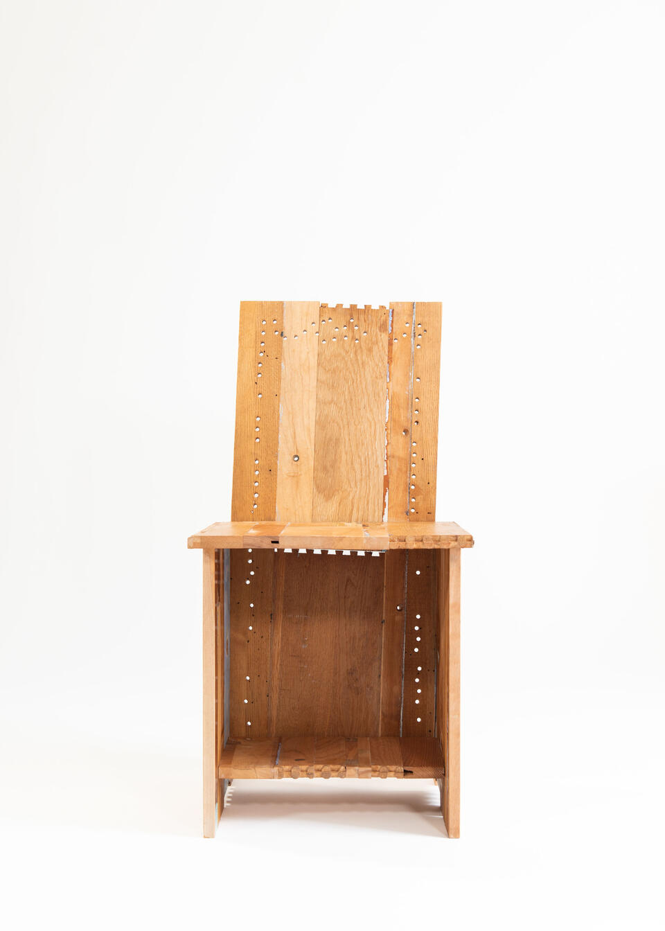 A chair made from the deconstructed materials of a found dresser painted in multiple colors.
