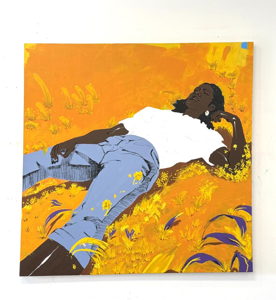 A Black woman lying in a golden field, surrounded by yellow and purple foliage, wearing a white t-shirt and light blue jeans.