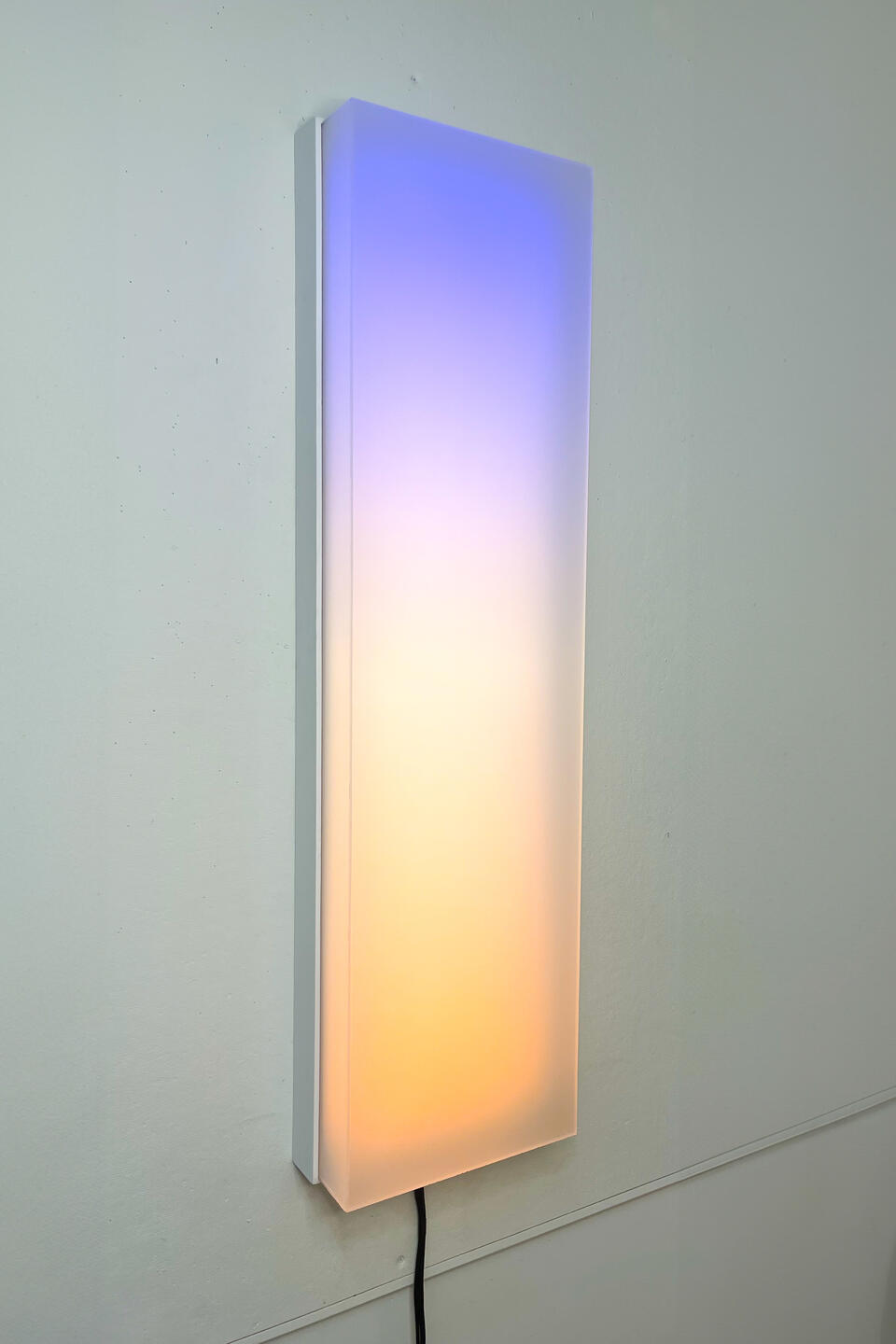 Four foot tall panel of light that shows a slow moving gradient and white lights that dance across
