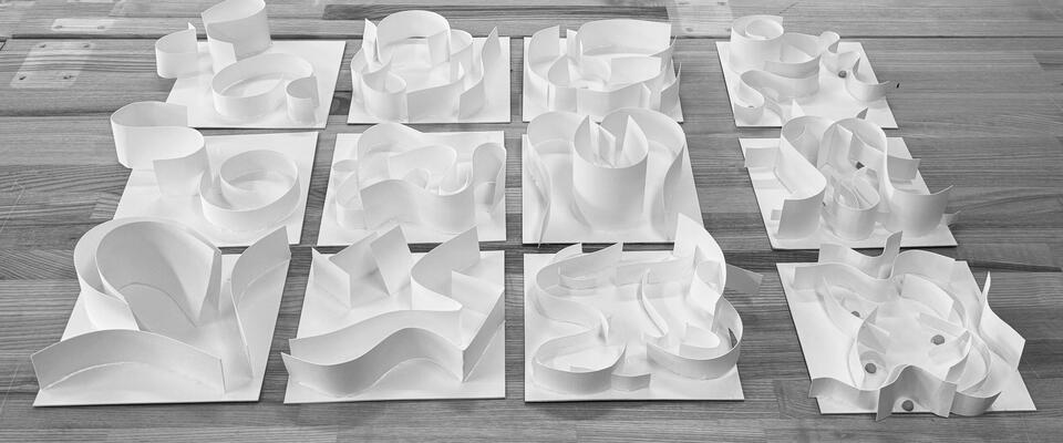 Twelve white paper models transform chair elements into abstract forms exploring space and movement