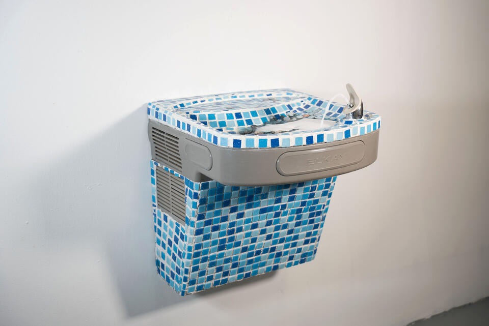 Tiled fountain flows with eroded coins and water, blending function and wishing well spirit—reflecting value, belief, memory.